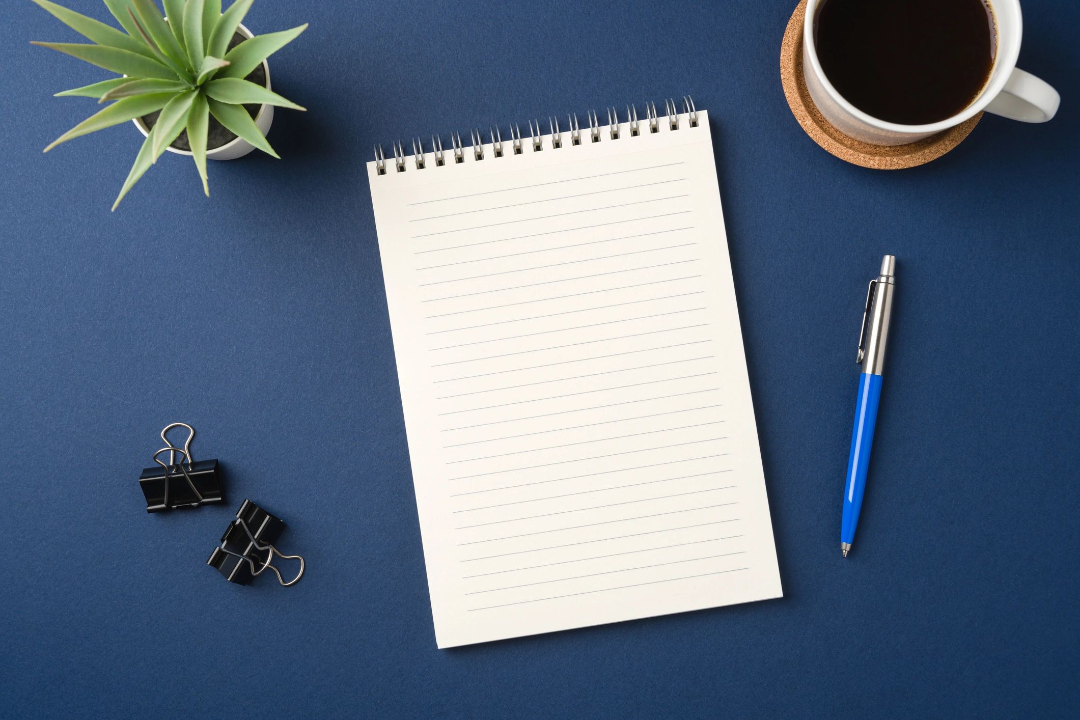 Top view of a minimal professional workspace with notebook and coffee